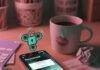 Best iPhone App for Password Management: My Hot Mess of a Journey Chaotic desk, phone with password app, coffee, and padlock