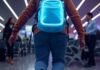 15 Must-Have Travel Gadgets Every Globetrotter Needs in 2025 Neon backpack gadgets in chaotic airport trip