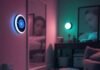 10 Genius Smart Home Gadgets That Will Change Your Life in 2025 Cluttered living room with smart thermostat, robot vacuum, spilled coffee, and smart mirror reflecting sleepy face, muted neon tones